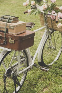 Vintage bicycle on the field with a basket of flowers